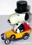 Large Snoopy in Tux driving yellow and purple car