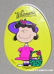 Lucy wearing bonnet standing next to Easter Basket Egg-Shaped Chocolate Box